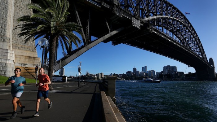 People jog under the Sydney Harbour Bridge in Sydney, Australia