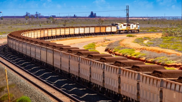 A freight train carries iron ore towards Port Hedland, Australia