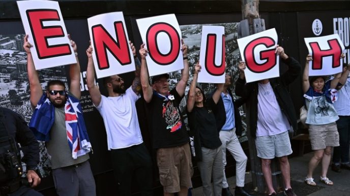 Individuals in the group hold up letters to spell the word “Enough”