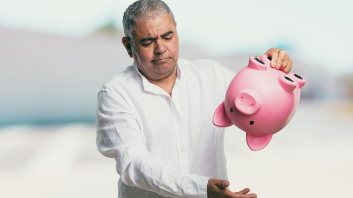 Man shakes empty piggy bank