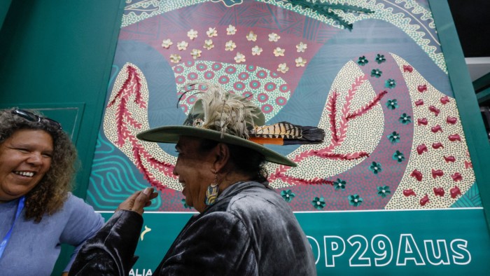 Participants stand near the Australia pavilion at COP29