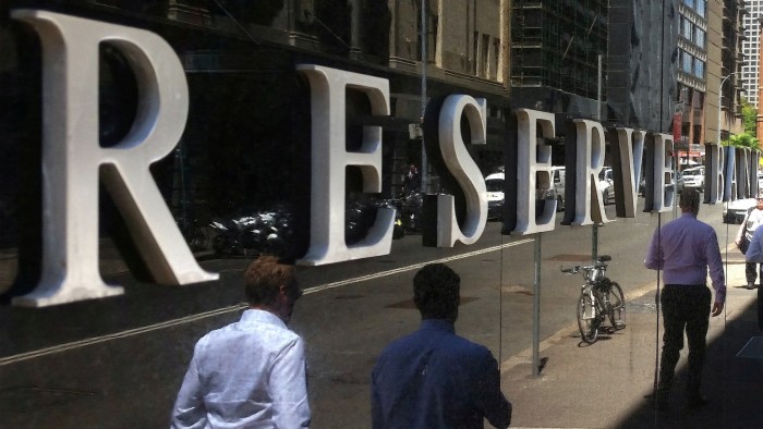 Pedestrians walk past the Reserve Bank of Australia building in central Sydney