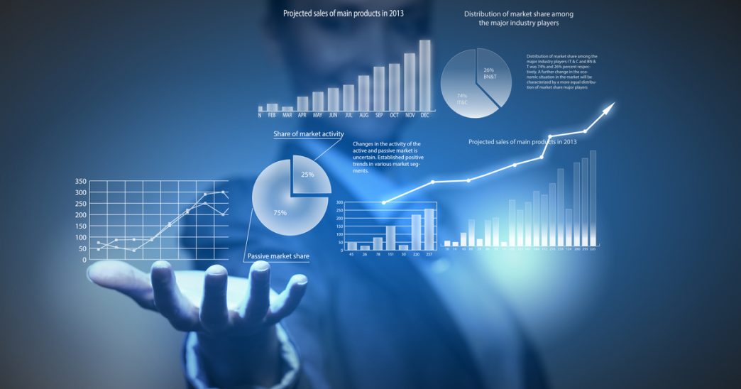 Hand holding up pie charts and graphs